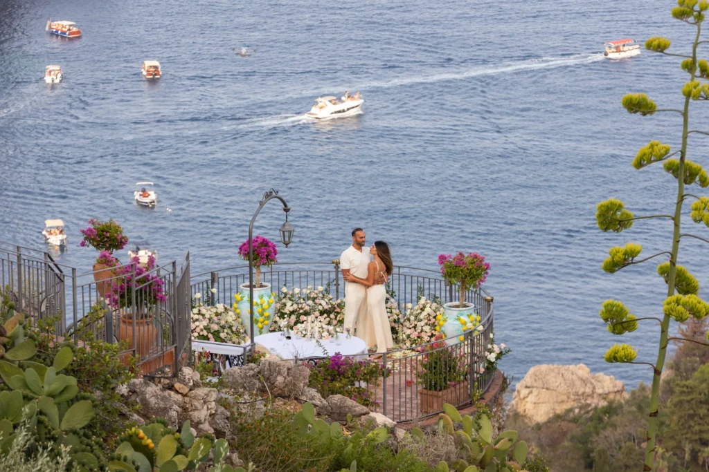 Engaged couple embracing on a terrace overlooking the sea in Taormina