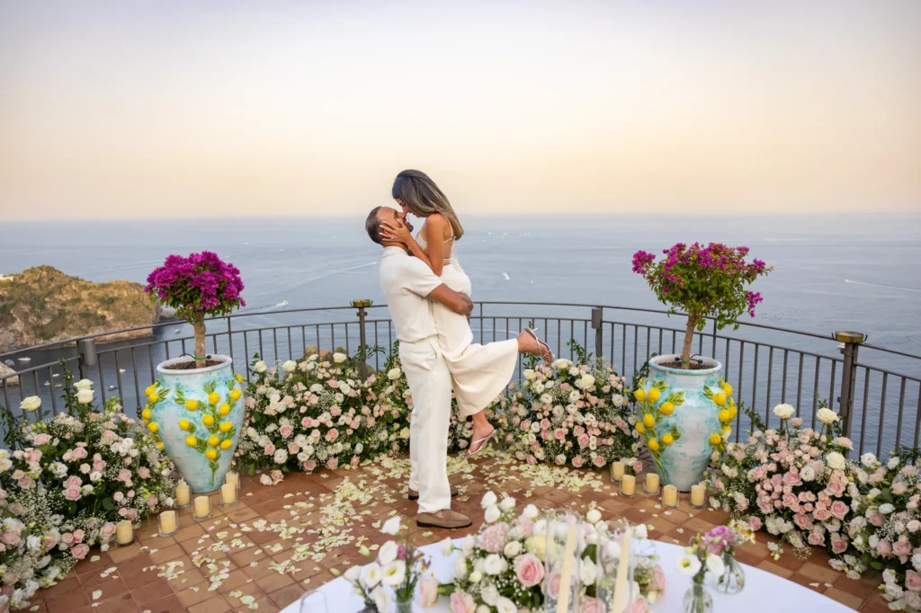 Couple kissing during a proposal celebration at sunset in Taormina