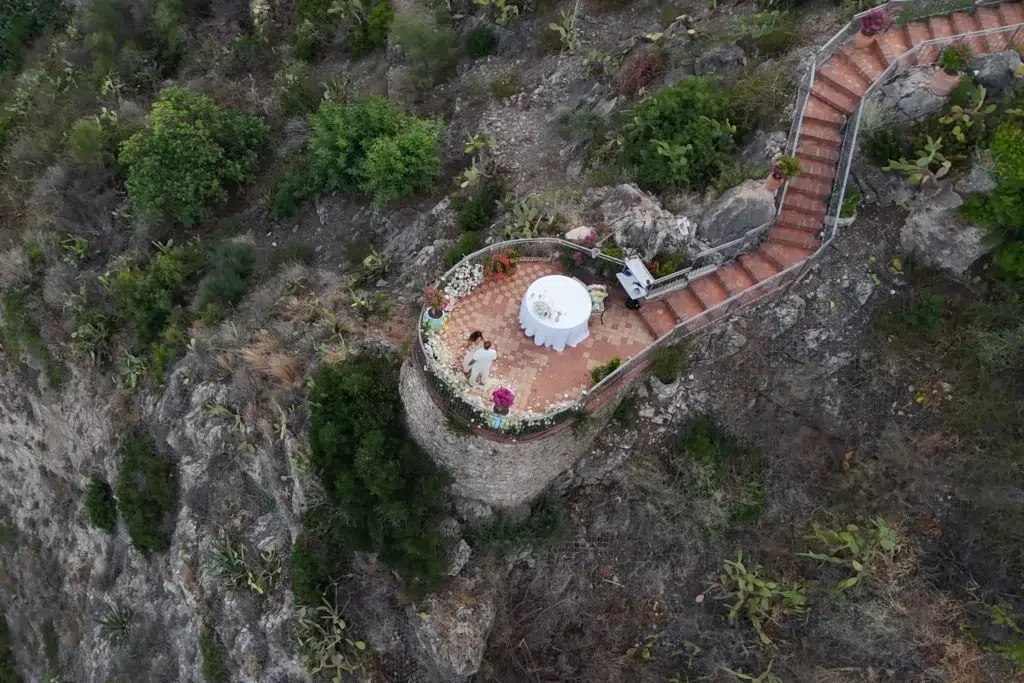 Aerial drone view of La Rotonda sul mare, the cliffside terrace of the Grand Hotel San Pietro, Taormina