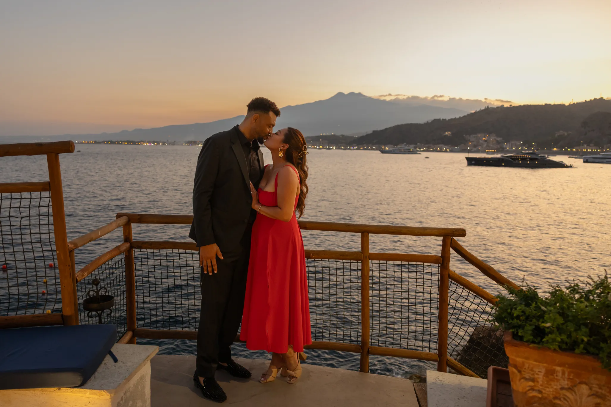 couple kissing on a terrace with Etna in the background